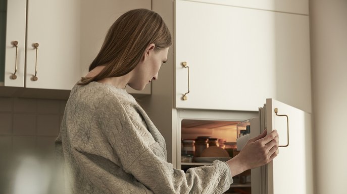 Bild zeigt Frau, die in den Kühlschrank schaut – Thema: Stromverbrauch von Kühlschränken.